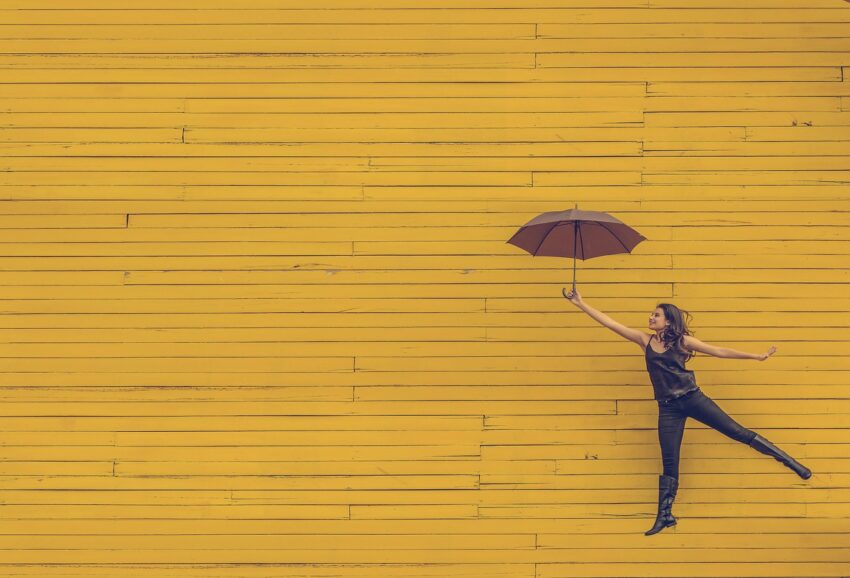 Someone jumping with an umbrella after conducting a life audit.