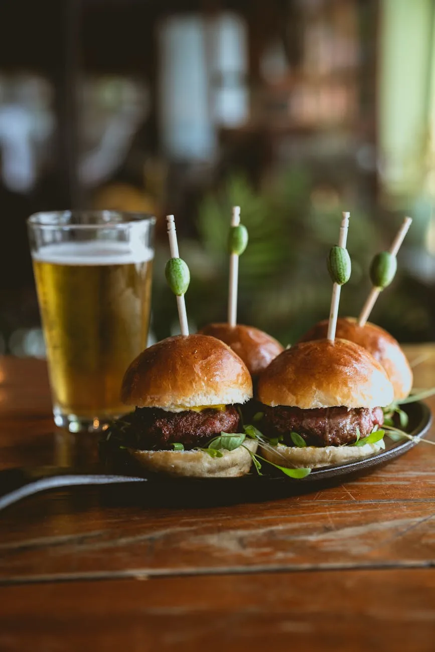 cheese burgers made out of glazed meatloaf leftovers, on a plate beside a glass of beer