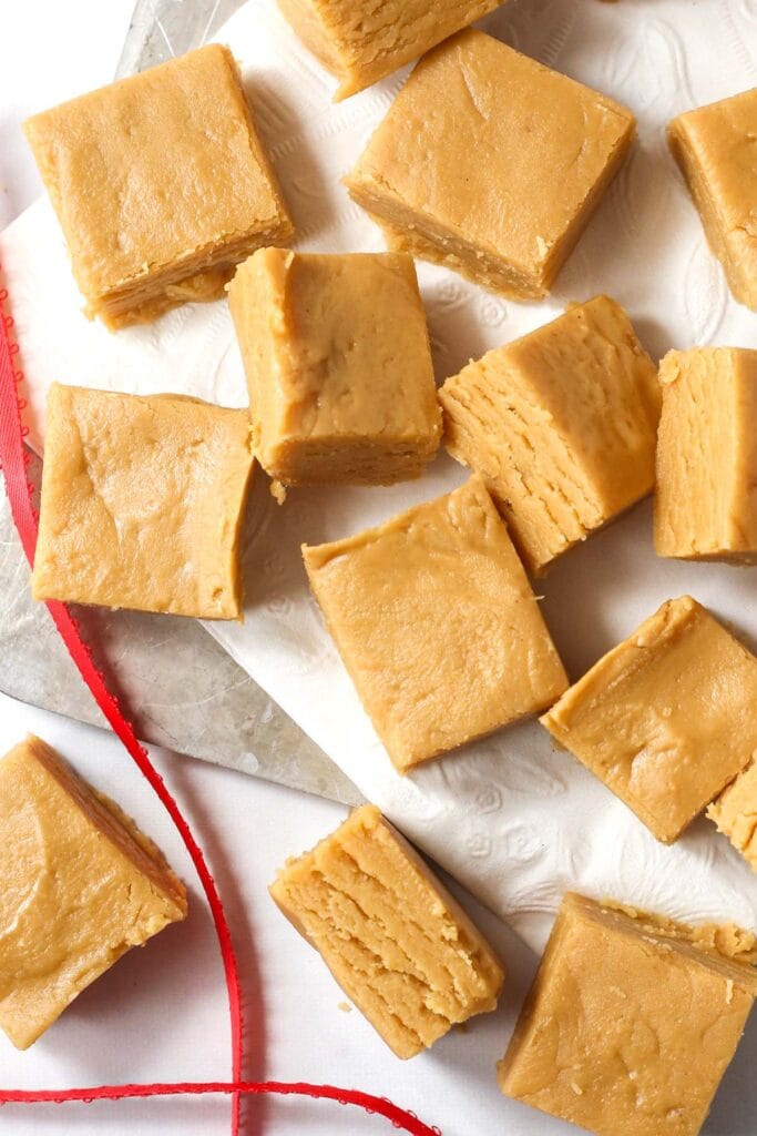 Squares of 2-Ingredient Peanut Butter Fudge arranged on parchment paper, a simple and budget-friendly option for Valentine's Dessert Ideas.