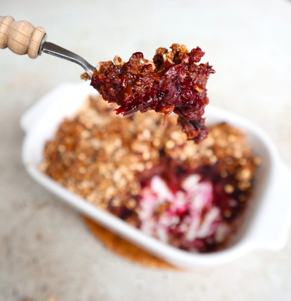 Warm Cherry Crumble served in a baking dish, with a forkful of sweet cherry filling and buttery crumble topping, a comforting choice for Valentine's Dessert Ideas.