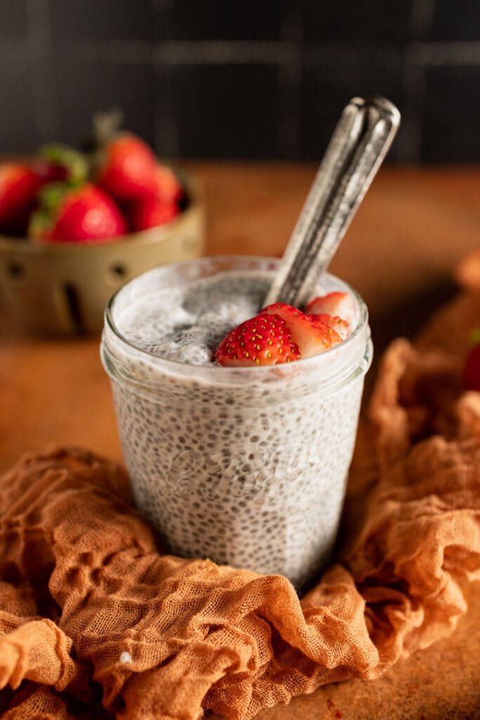 A creamy Coconut Milk Chia Pudding served in a glass jar, topped with fresh strawberries, perfect for healthy and elegant Valentine's Dessert Ideas.