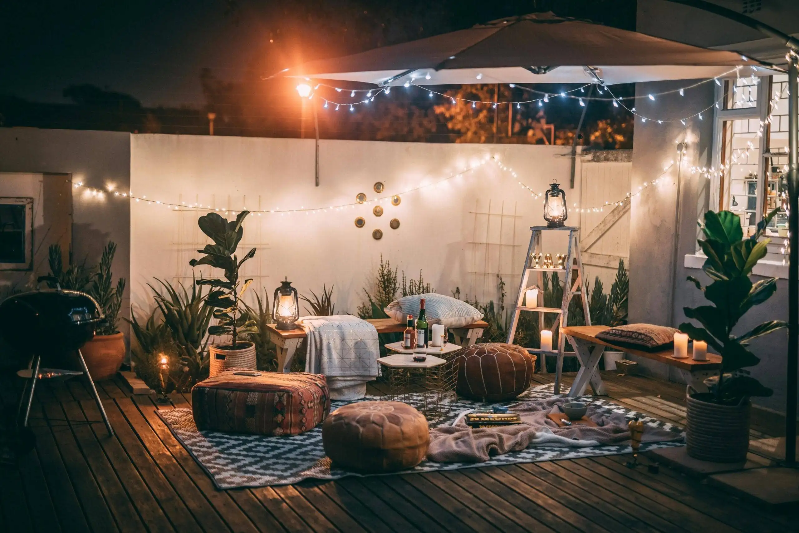 Cheap Date Night Ideas (at Home) That Will Make You Fall in Love Again Inviting outdoor patio setup at night featuring cozy seating, string lights, and decor for perfect relaxation.