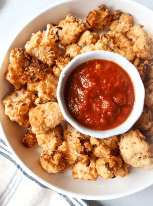 Crispy air fryer cauliflower bites served with a bowl of marinara sauce—an easy, healthier option for Super Bowl food ideas.