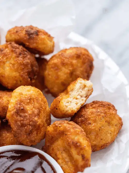 Air fryer chicken nuggets with a crispy golden crust, served with barbecue dipping sauce—an easy and kid-friendly choice for Super Bowl food ideas.