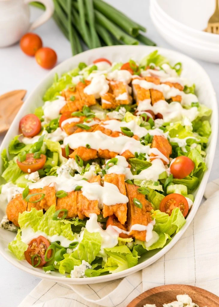 A vibrant buffalo turkey salad with fresh greens, cherry tomatoes, and a drizzle of ranch dressing, showcasing a zero-waste approach to leftovers recipes.







