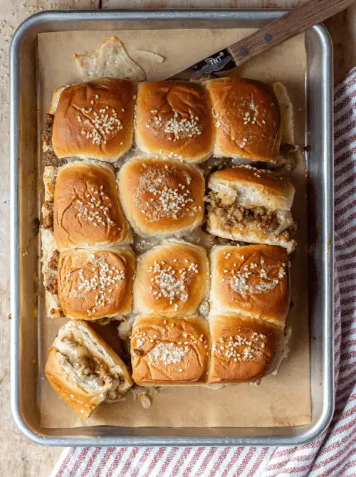 Cheeseburger sliders baked on Hawaiian rolls, topped with sesame seeds—an easy, crowd-pleasing option for Super Bowl food ideas.