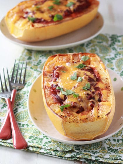 Stuffed spaghetti squash halves filled with a savory tomato and cheese mixture, baked to perfection and garnished with fresh herbs—a creative and healthy way to reinvent leftovers into a delicious meal.