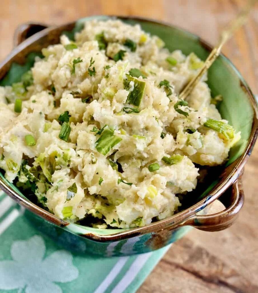 Rustic bowl of traditional Irish colcannon, featuring mashed potatoes mixed with cabbage, scallions, and parsley, perfect for St. Patrick's Day food ideas and authentic Irish recipes.