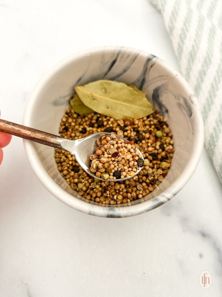 Small marble bowl filled with  spices and bay leaves, ideal for seasoning corned beef and other dishes, perfect for St. Patrick's Day food ideas and Irish-inspired recipes.