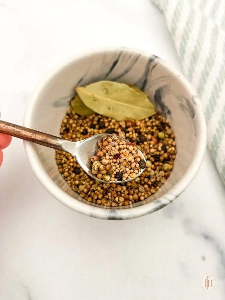 Small marble bowl filled with  spices and bay leaves, ideal for seasoning corned beef and other dishes, perfect for St. Patrick's Day food ideas and Irish-inspired recipes.