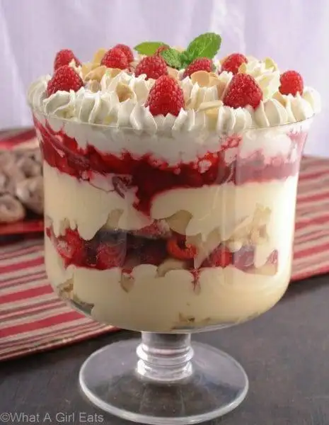 A layered raspberry trifle with whipped cream and fresh raspberries, an elegant and delicious choice for romantic desserts for two.