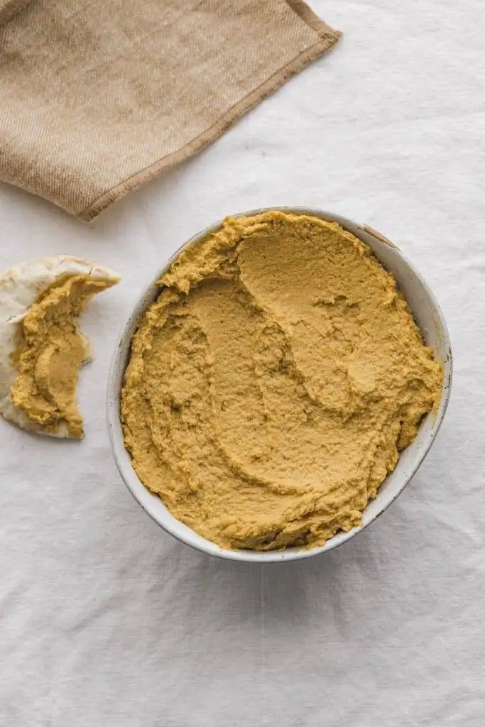 Smooth and creamy homemade hummus served in a white bowl, a healthy and versatile choice among the best party dips.