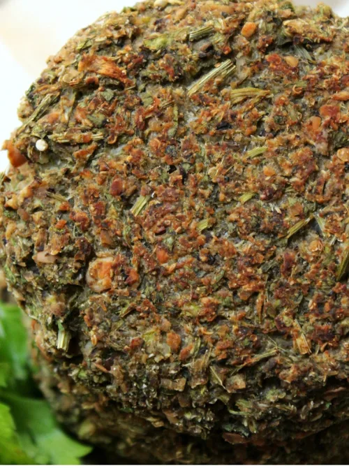 Close-up of a crispy, golden-brown veggie patty made with a mix of herbs, vegetables, and grains—a nutritious and flavorful option for creative leftovers recipes.