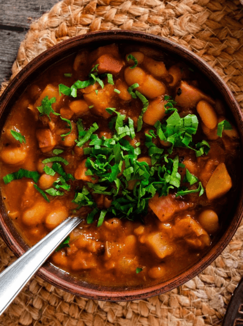 Rustic bowl of hearty ham and bean soup, garnished with fresh parsley, perfect for cozy and quick meals with ham.