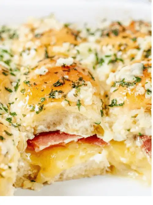Ham and cheese sliders baked with a buttery garlic glaze—gooey, savory bites perfect for Super Bowl food ideas.