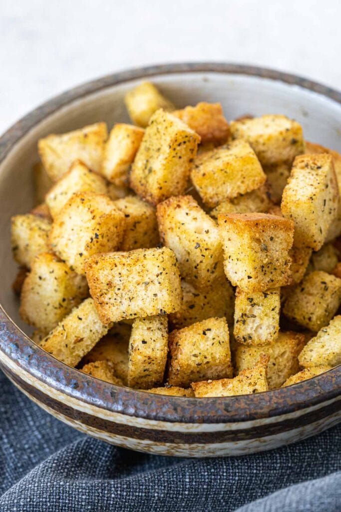 Close-up of a bowl filled with crispy, golden-brown homemade croutons, seasoned to perfection—an ideal addition to leftovers recipes for soups, salads, or snacks.