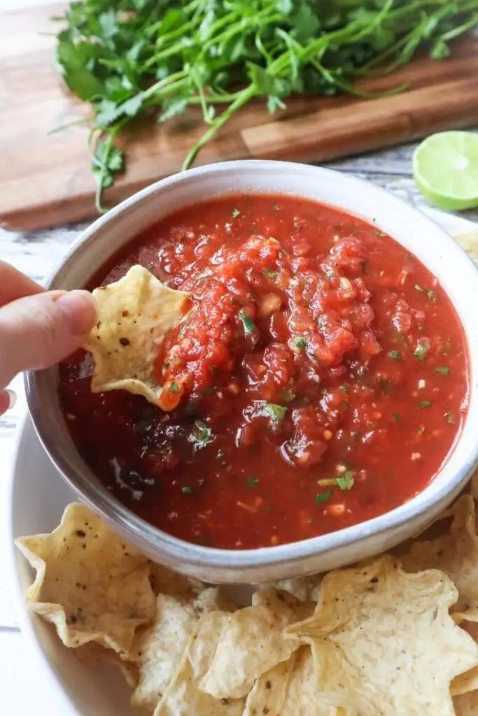 Fresh and zesty homemade salsa with cilantro, served with tortilla chips—an all-time favorite among the best party dips.
