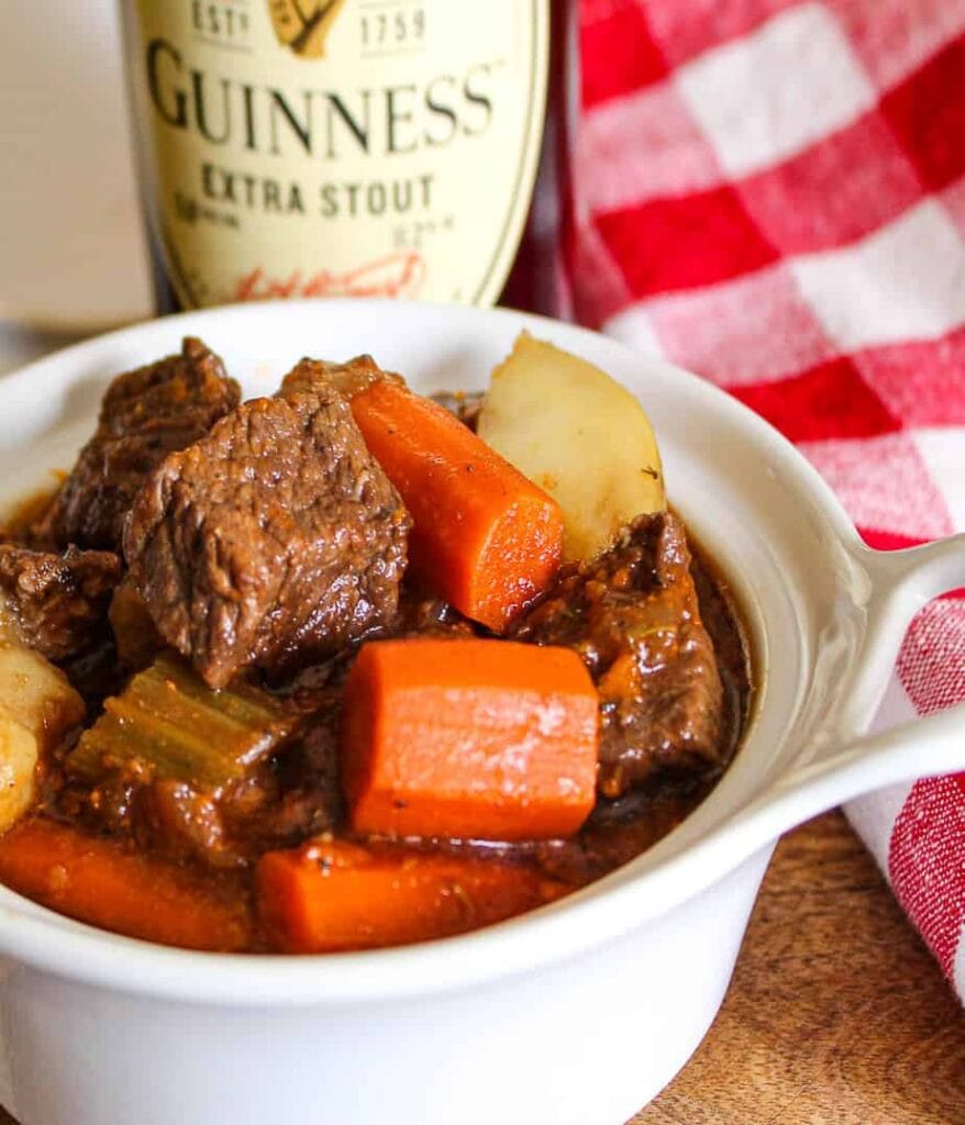 Hearty Guinness beef stew with tender chunks of beef, carrots, celery, and potatoes in a rich stout-infused gravy, perfect for St. Patrick's Day food ideas and traditional Irish recipes.