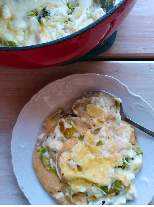 Dish of creamy Irish colcannon potato bake with melted cheese, featuring layers of cabbage, potatoes, and rich sauce—perfect for St. Patrick's Day food ideas and traditional Irish comfort recipes.