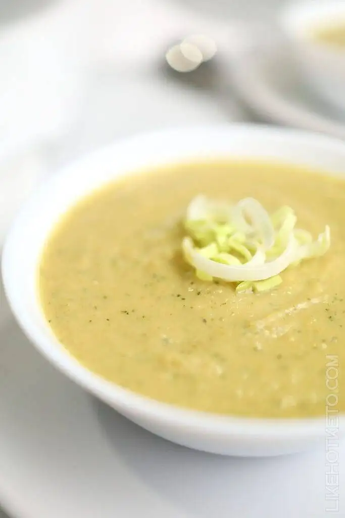 Smooth and creamy bowl of leek and potato soup, garnished with fresh sliced leeks, perfect for St. Patrick's Day food ideas and traditional Irish recipes.