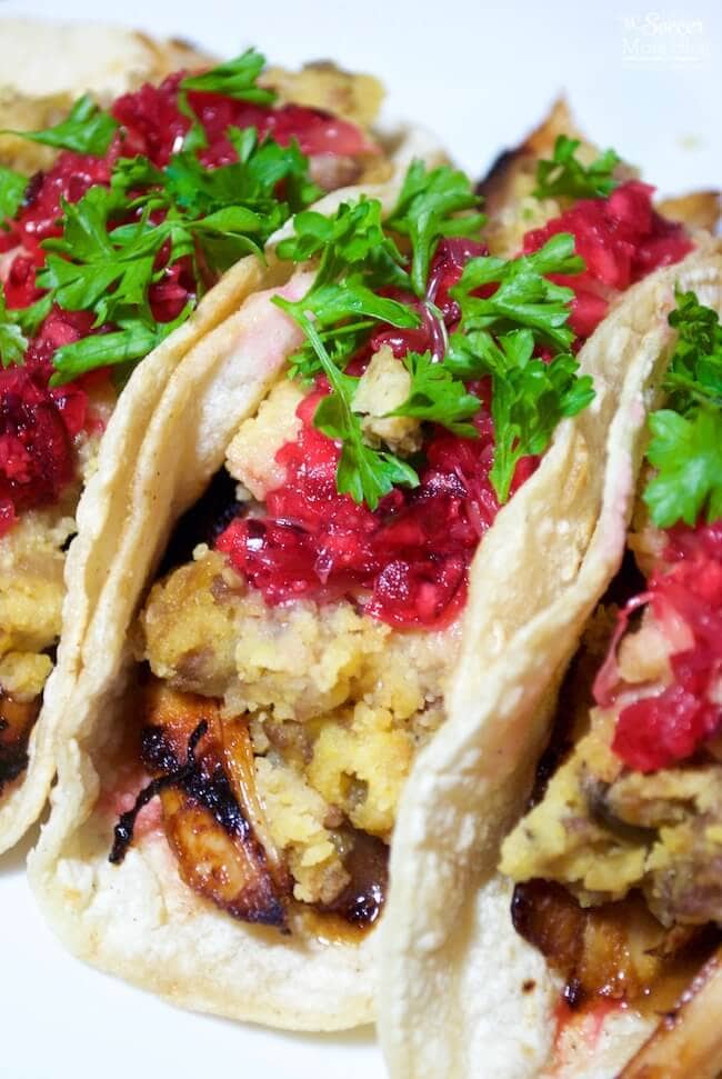 Soft tacos filled with leftover turkey, stuffing, and cranberry sauce, topped with fresh parsley, showcasing a zero-waste approach to leftovers recipes.