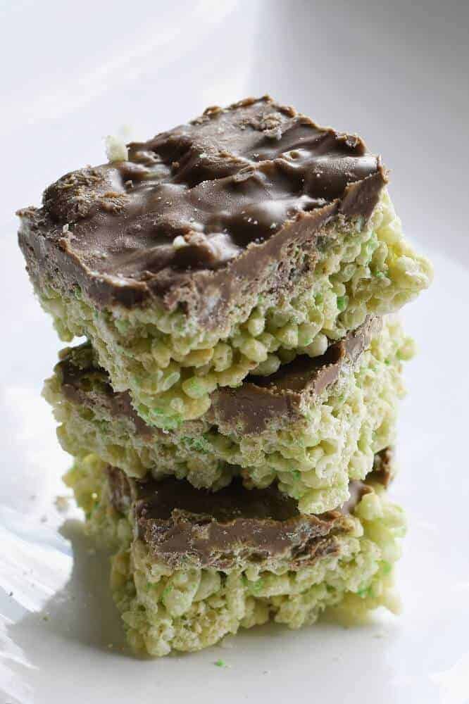 Stack of chocolate-topped green rice cereal treats, a festive dessert perfect for St. Patrick's Day food ideas and sweet Irish-inspired celebrations.