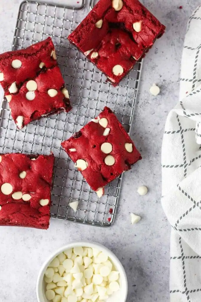 Red velvet brownies with white chocolate chips on a cooling rack, a rich and vibrant choice for romantic desserts for two.