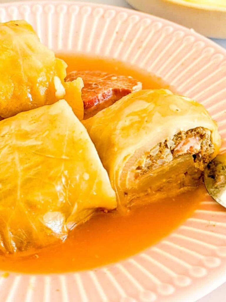 Plate of stuffed cabbage rolls filled with a savory meat and rice mixture, smothered in a rich tomato-based sauce—a comforting and flavorful way to use leftovers creatively.S