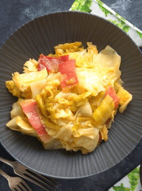 Plate of stewed cabbage with tender slices of corned beef, a comforting and flavorful dish perfect for St. Patrick's Day food ideas and traditional Irish recipes.