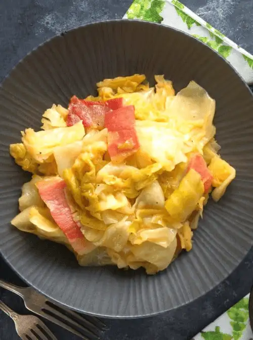 Plate of stewed cabbage with tender slices of corned beef, a comforting and flavorful dish perfect for St. Patrick's Day food ideas and traditional Irish recipes.
