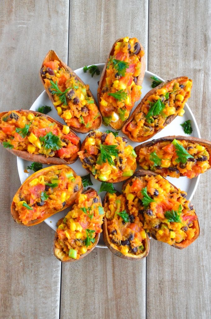 Plate of vibrant stuffed sweet potato skins filled with black beans, corn, tomatoes, and fresh herbs—a colorful and nutritious choice for creative leftovers recipes.