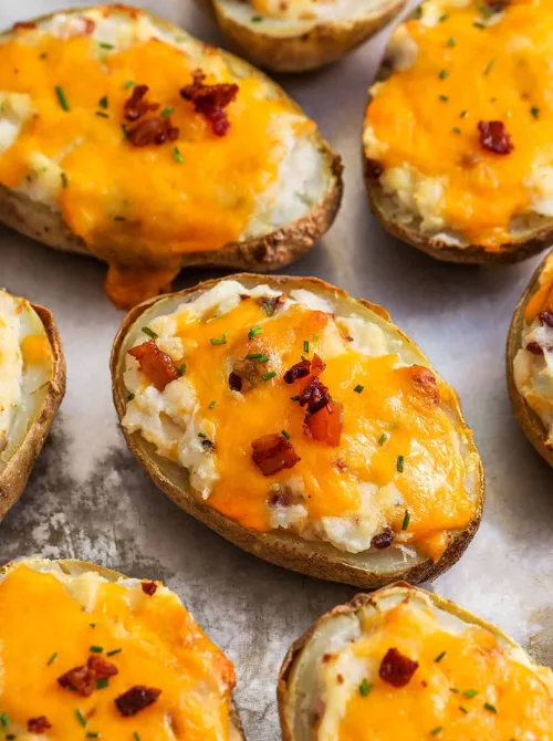 Cheesy twice-baked potatoes topped with crispy bacon and chives—hearty and comforting for Super Bowl food ideas.