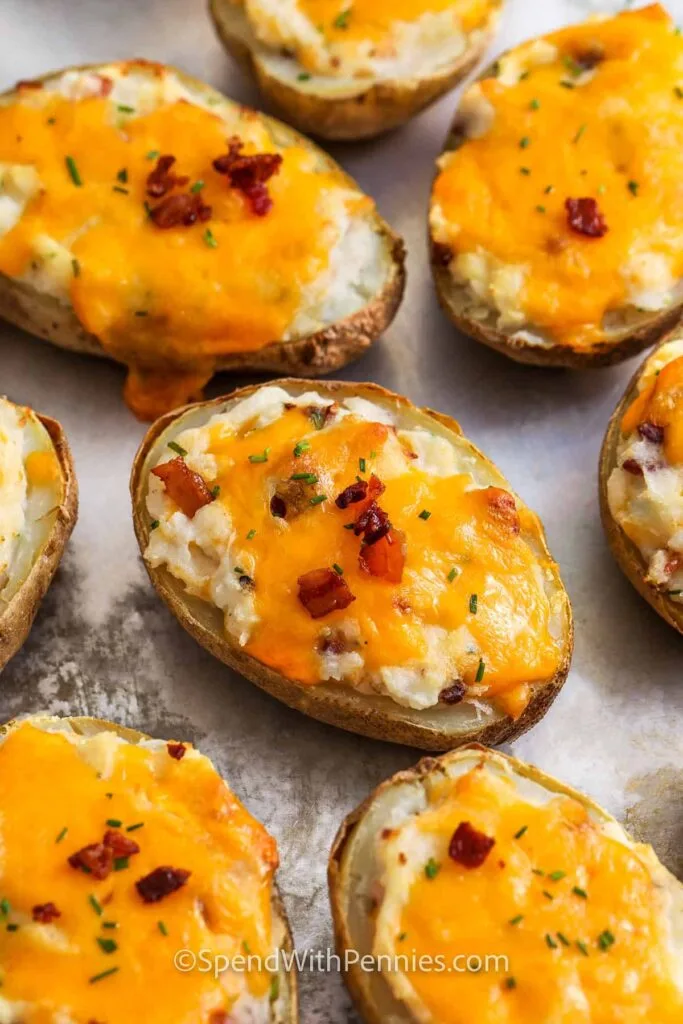 Twice-baked potatoes topped with melted cheddar cheese and crispy bacon bits, garnished with fresh chives. A hearty and satisfying Super Bowl food idea for game day celebrations.