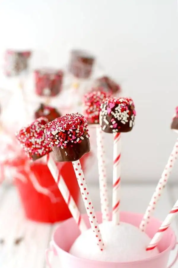 Chocolate-dipped marshmallow pops with colorful sprinkles, a fun and festive choice for romantic desserts for two.
