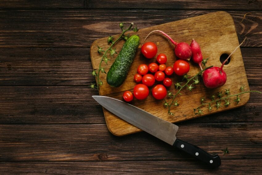 assorted vegetables and knife on wooden chopping board