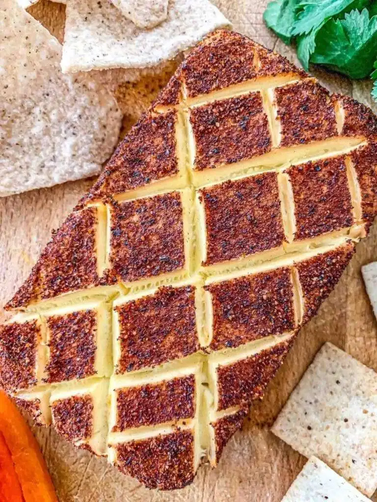 Smoky, baked cheese block scored for easy dipping, served with crackers and chips—an elegant addition to the best party dips spread.