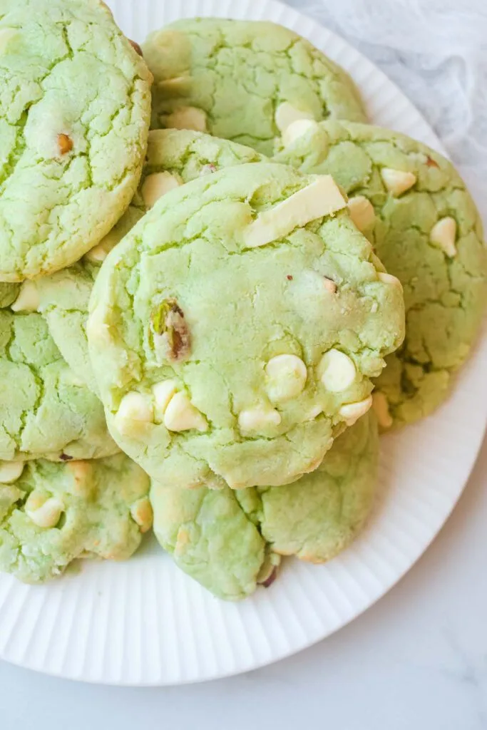 A plate of soft green cookies filled with white chocolate chips and pistachios, perfect for St Patrick's Day desserts or Irish-themed treats.