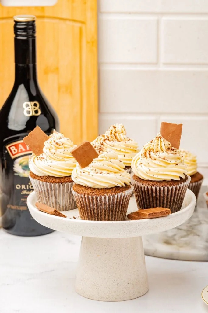 Delicious Irish cream cupcakes topped with swirls of frosting, cinnamon, and chocolate pieces, perfect for St. Patrick's Day desserts or festive gatherings.