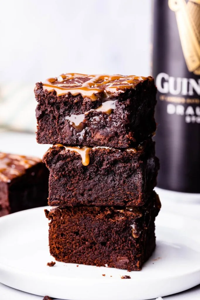 A stack of rich Guinness chocolate brownies drizzled with caramel sauce, perfect for St. Patrick's Day desserts or indulgent Irish-inspired treats.