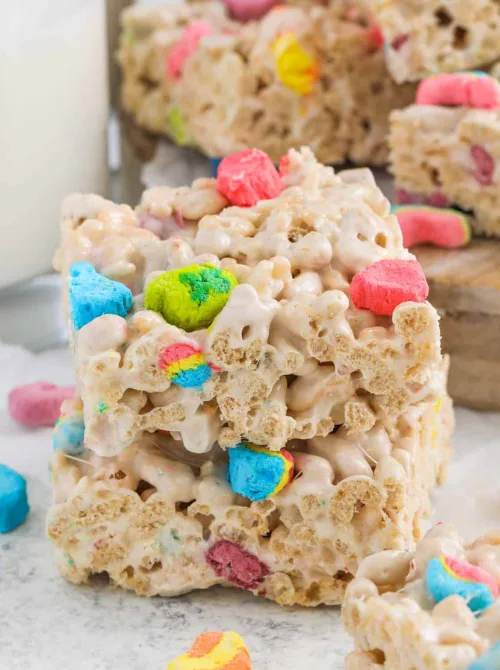 Stacked marshmallow cereal bars with colorful Lucky Charms marshmallows, perfect for festive St. Patrick's Day treats or a fun snack.