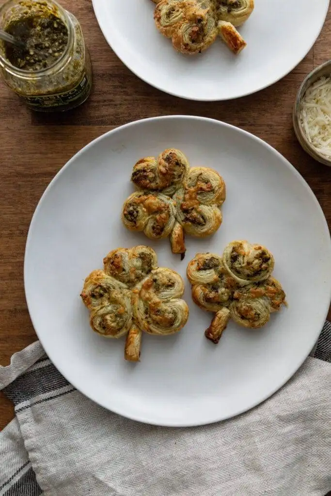 Shamrock-shaped puff pastry bites filled with pesto and cheese, offering a festive and flavorful appetizer perfect for Irish party food celebrations.