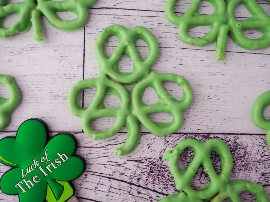 Shamrock-shaped pretzels coated in green chocolate, perfect for festive St. Patrick's Day desserts or Irish-themed treats.