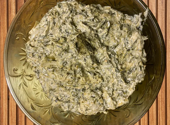 Asian fusion easy spinach dip with a creamy, savory texture, infused with rich umami flavors and a hint of pickled onions for a tangy kick, served in a decorative bowl.