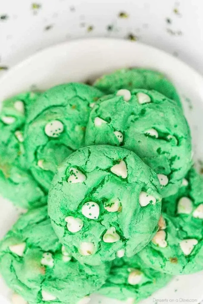 A plate of green cookies studded with white chocolate chips, perfect for festive St. Patrick's Day desserts or Irish-themed treats.