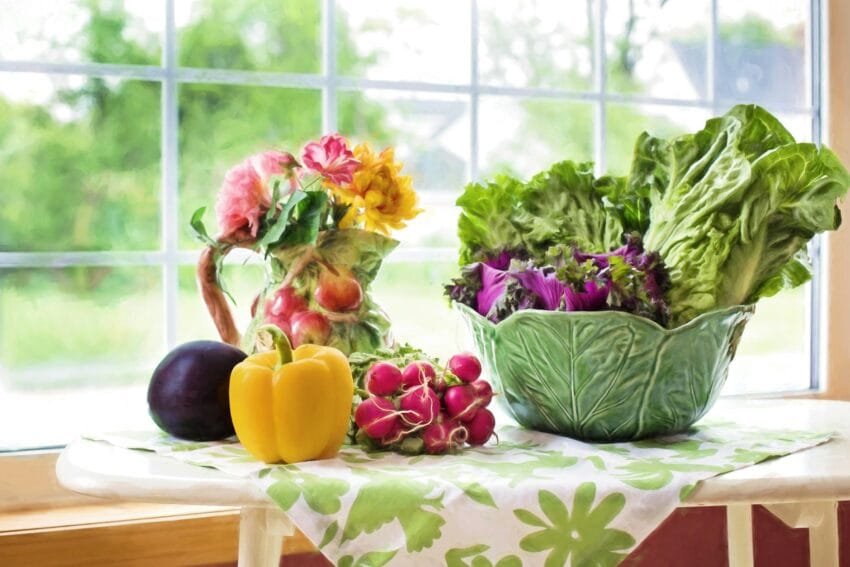 yellow bell pepper beside red cherry tomato near green ceramic bowl