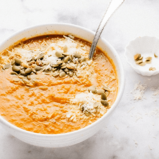 A warm and creamy farm to table roasted carrot soup, topped with crunchy pumpkin seeds and freshly grated parmesan cheese. The vibrant orange color and smooth texture highlight the richness of farm-fresh ingredients, making this nourishing dish both comforting and full of flavor. Perfect for a cozy, wholesome meal.