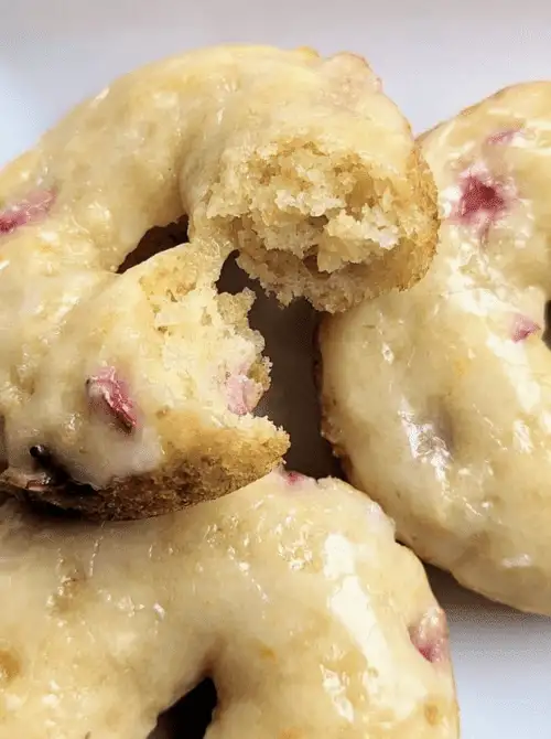 Close-up of glazed strawberry donuts, soft and fluffy, perfect for a budget-friendly Easter brunch.