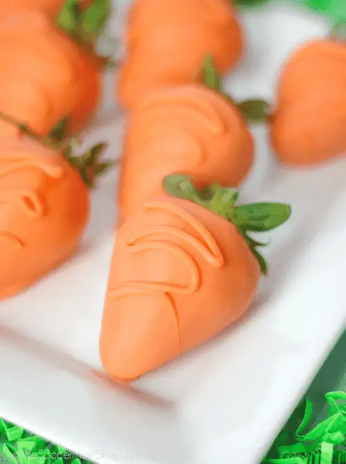 Chocolate-dipped strawberries designed to look like carrots—perfect for easy Easter finger food ideas. A festive and fun treat for spring celebrations and dessert tables.