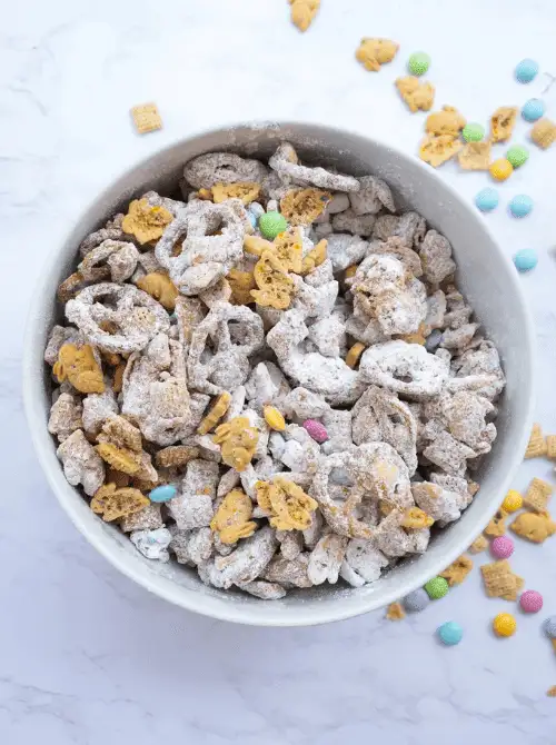 Easter Bunny Chow snack mix made with powdered sugar-coated cereal, pretzels, and pastel candies—perfect for easy Easter finger food ideas and a festive party treat!