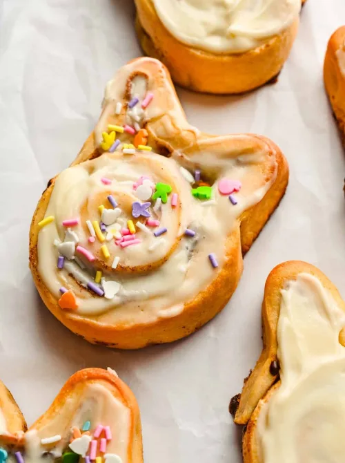 Adorable bunny-shaped cinnamon rolls topped with creamy icing and colorful sprinkles, perfect for a budget-friendly Easter brunch.